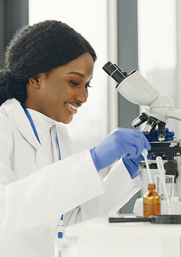 scientist with microscope and dropper